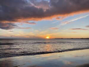 A pink and orange sunset at the beach